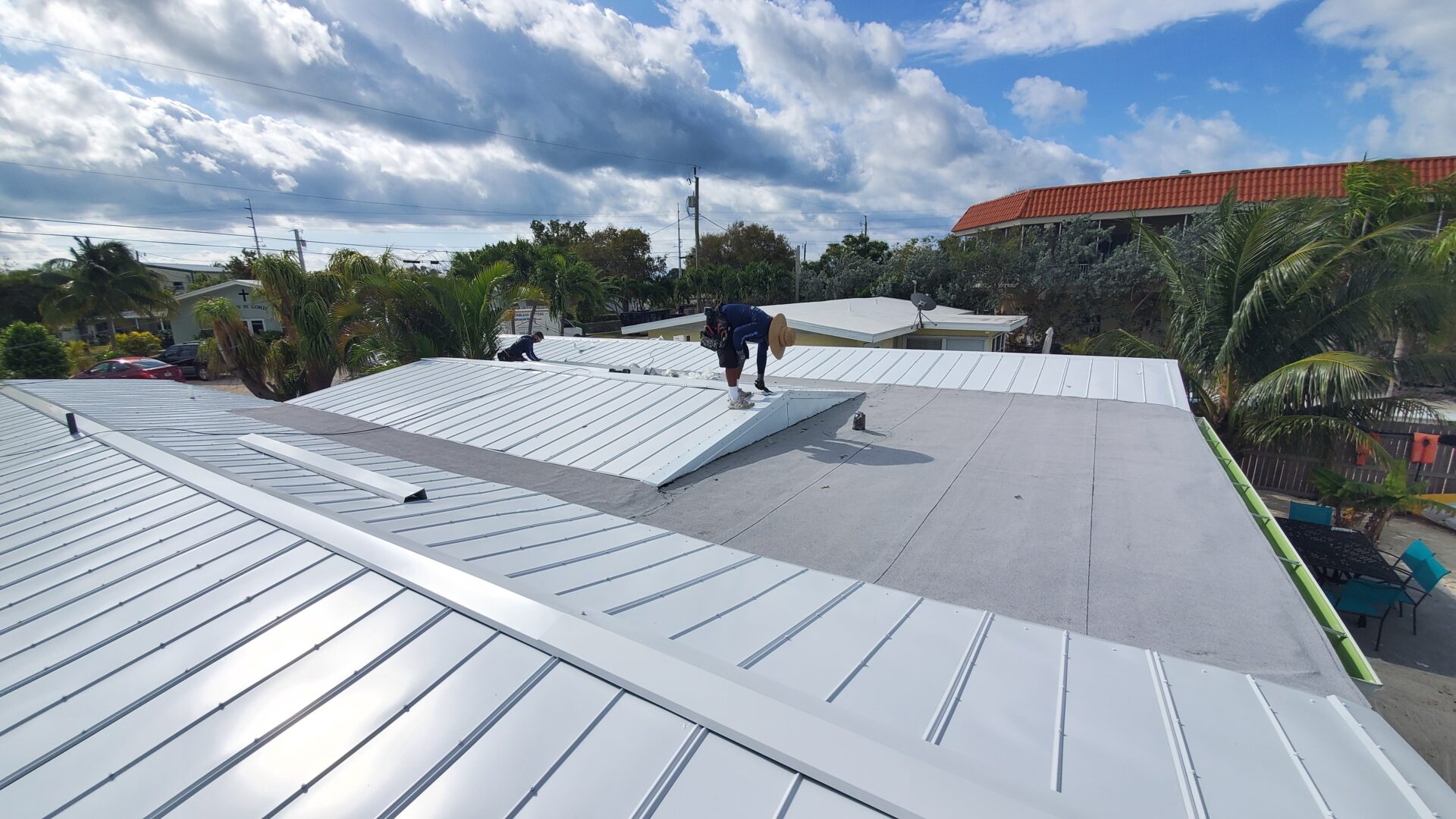 A man installing white roofing