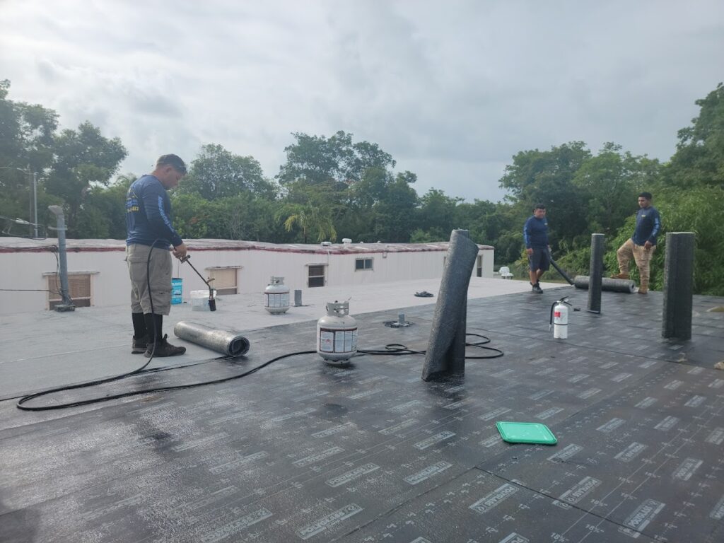 Workers performing maintenance on flat commercial roof