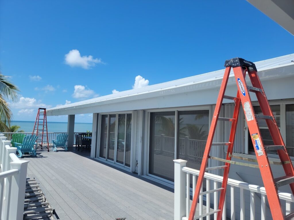 Modern building with flat roof and worker using ladder for inspection