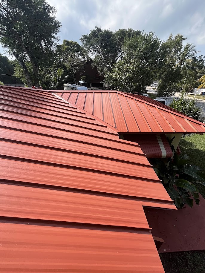 Red metal roofing panels installed on residential building