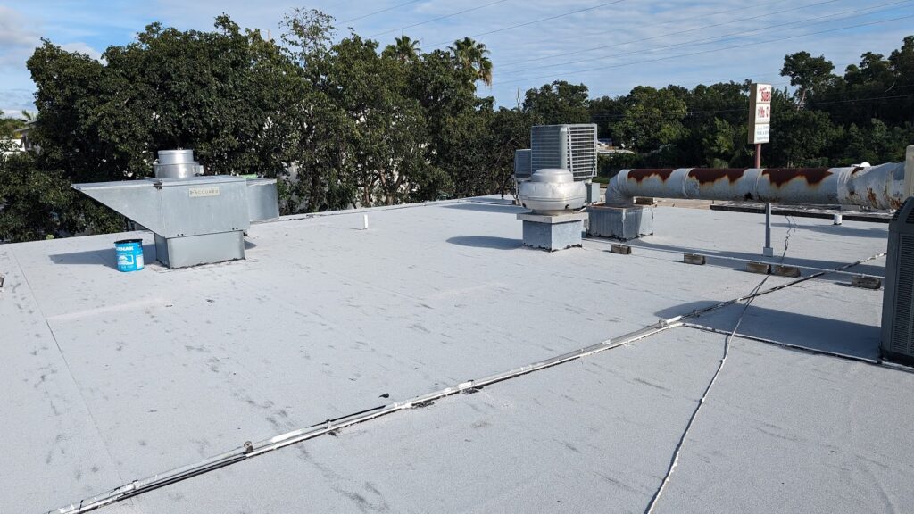 Flat commercial roof with ventilation units and white coating